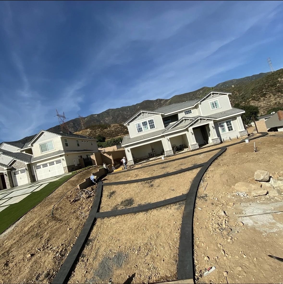 Curved driveway borders formed on a hillside new build